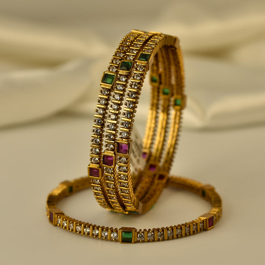 Antique Gold polish ad bangles with gemstones like stone on a beige fabric background
