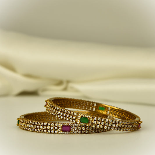 AD Bangle with antique gold polish with diamond like white stone highlighted with square cut green and ruby color stone