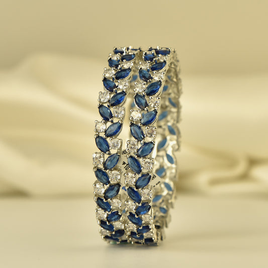 silver polish ad Bangle with blue and white color stones on a beige background